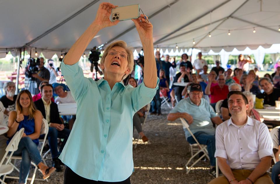 U.S. Sen. Elizabeth Warren takes a selfie with supporters at a rally at Belkin Family Lookout Farm in Natick, Aug. 24, 2022.