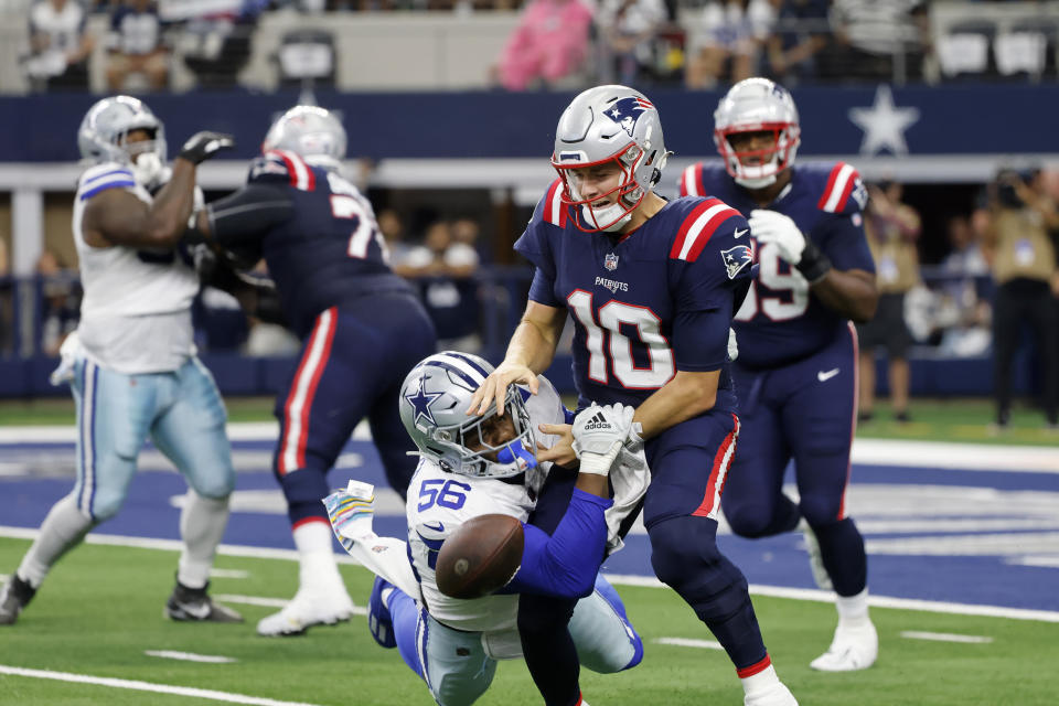 Dallas Cowboys defensive end Dante Fowler Jr. (56) strips the ball away from New England Patriots quarterback Mac Jones (10) in the first half of Sunday's game. (AP Photo/Michael Ainsworth)