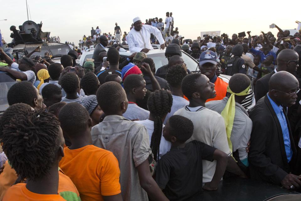 Gambian President Adama Barrow, centre, rides his motorcade through crowds of hundreds of thousands after arriving at Banjul airport in Gambia, Thursday Jan. 26, 2017, after flying in from Dakar, Senegal. Gambia's new president has finally arrived in the country, a week after taking the oath of office abroad amid a whirlwind political crisis. Here's a look at the tumble of events that led to Adama Barrow's return — and the exile of the country's longtime leader. (AP Photo/Jerome Delay)