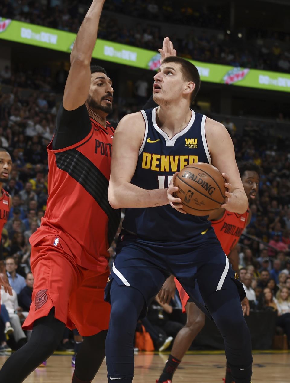Denver Nuggets center Nikola Jokic, right, goes up for a basket Portland Trail Blazers center Enes Kanter, left, in the first half of Game 7 of an NBA basketball second-round playoff series Sunday, May 12, 2019, in Denver. (AP Photo/John Leyba)