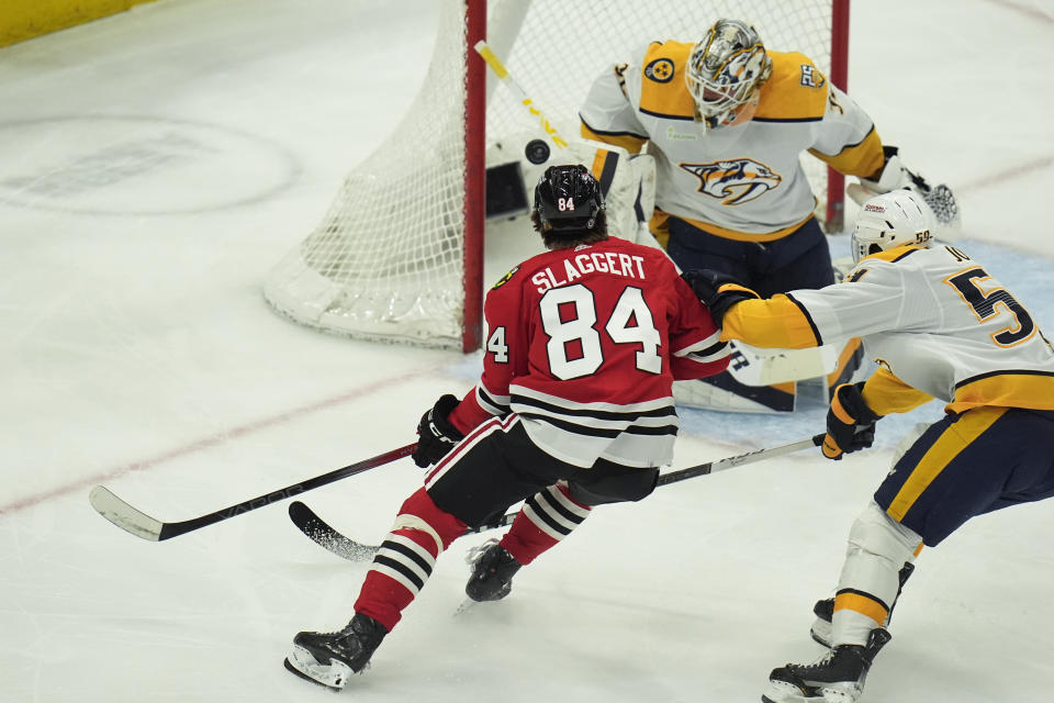 Nashville Predators goaltender Kevin Lankinen, right, blocks a shot from Chicago Blackhawks left wing Landon Slaggert during the first period of an NHL hockey game Friday, April 12, 2024, in Chicago. (AP Photo/Erin Hooley)