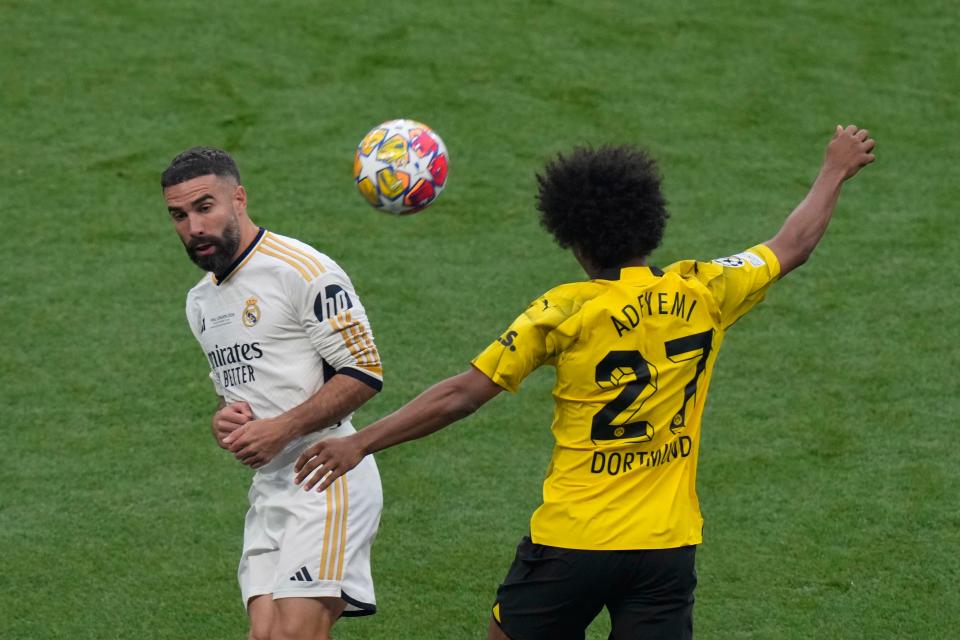 Dortmund’s Karim Adeyemi, right, heads the ball past Real Madrid’s Dani Carvajal (AP)
