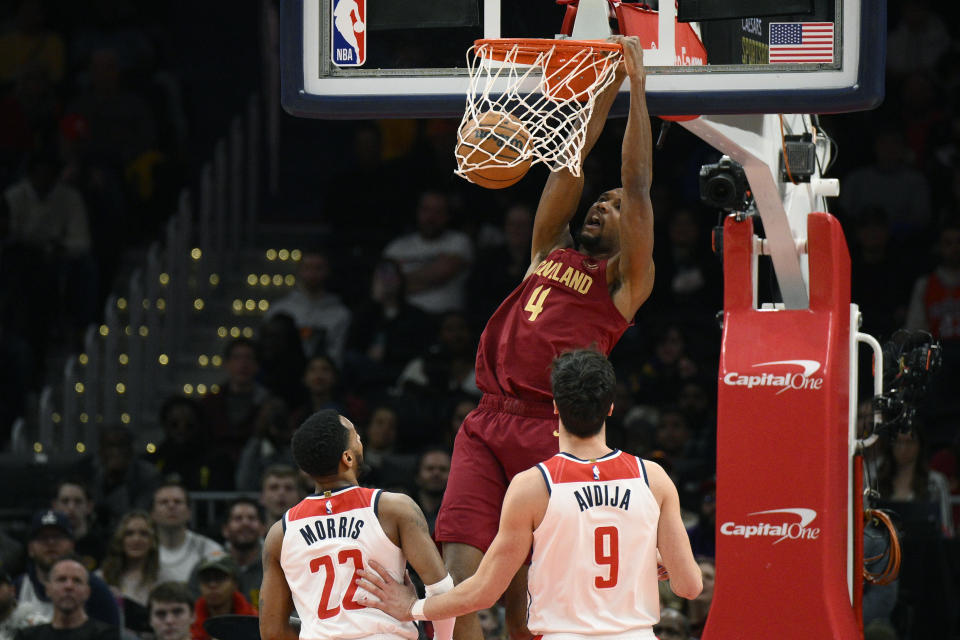 Cleveland Cavaliers forward Evan Mobley (4) dunks over Washington Wizards guard Monte Morris (22) and forward Deni Avdija (9) during the first half of an NBA basketball game, Monday, Feb. 6, 2023, in Washington. (AP Photo/Nick Wass)