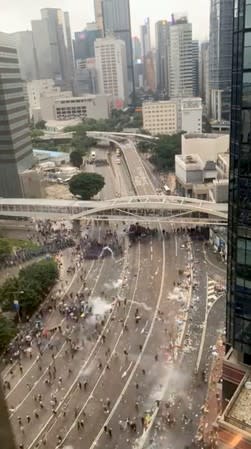 Protesters react to a tear gas during a demonstration against an extradition bill in Hong Kong