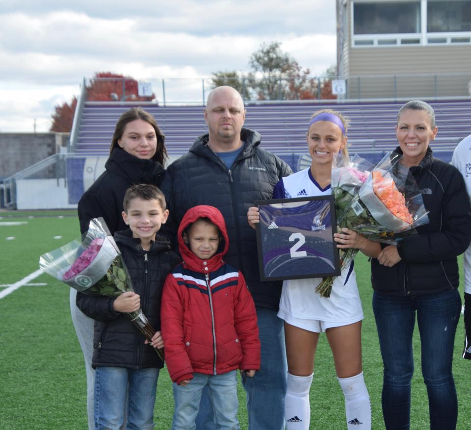 Luke and Cooper Roberts stand with their family, including their mother, Keely Roberts, for a family photo.