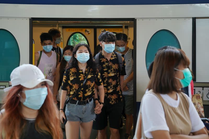 People walk out of a train at a subway station near the Hong Kong Disneyland Resort in Hong Kong