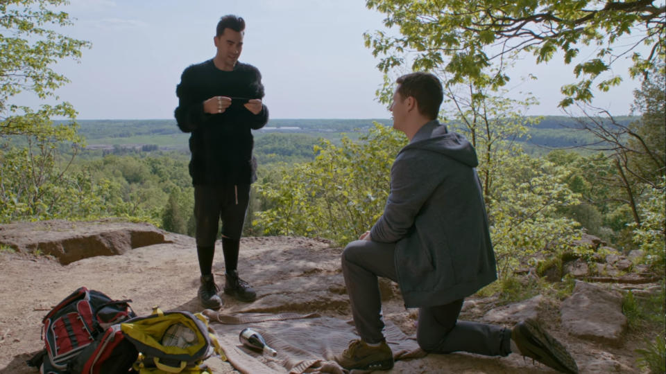 David and Patrick on a hike; Patrick down on one knee proposing to David