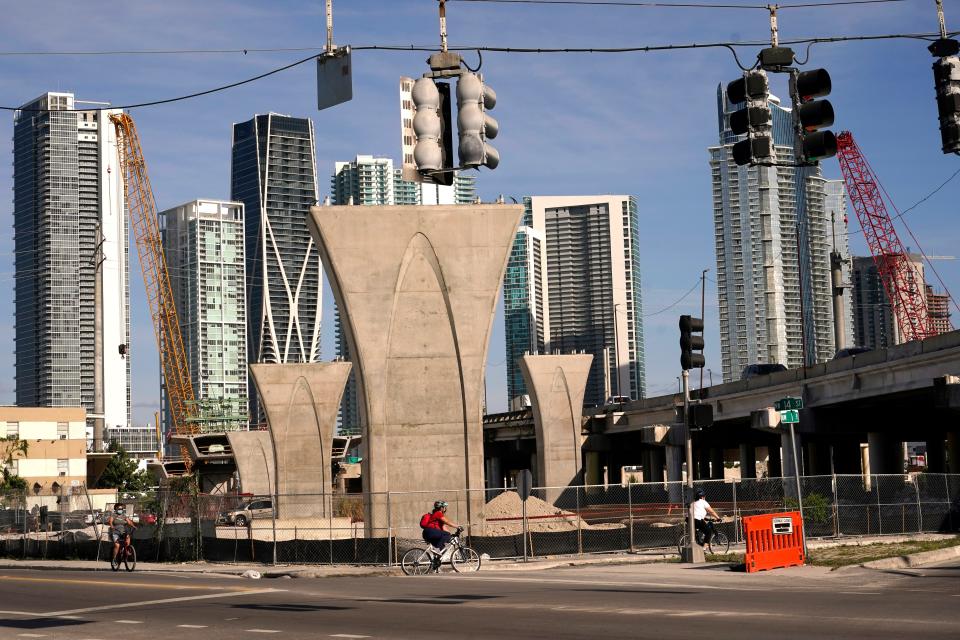 Columns for the new Signature Bridge are in place April 9, 2021, in the Overtown neighborhood of Miami. At right is the Interstate 395 bridge built in the 1960s, which forced out thousands of residents. The Signature Bridge project coincides with the revitalization of the neighborhood. Community leaders work to ensure that Overtown's Black history and culture are preserved in the process.