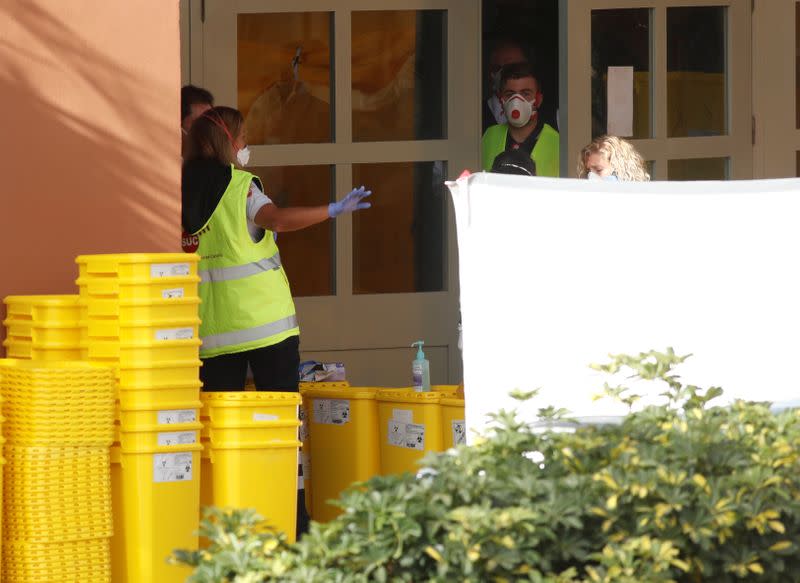 Emergency workers rest outside H10 Costa Adeje Palace, which is on lockdown after cases of coronavirus have been detected there in Adeje