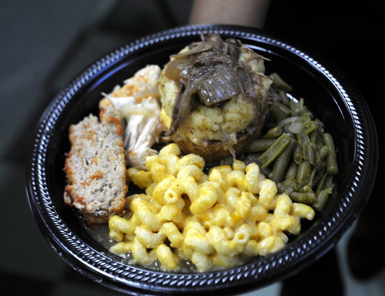 A plate of meatloaf, macaroni and cheese, green beans, mashed potatoes with tender beer, and pulled chicken from Peace 4U Hospitality are served at a community giveback event on February 25, 2024.