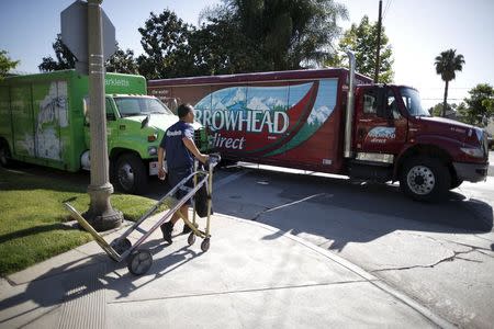 A Sparkletts bottled water delivery driver (L) greets an Arrowhead bottled water delivery driver as they take water to homes in Los Angeles, California, April 17, 2015. REUTERS/Lucy Nicholson