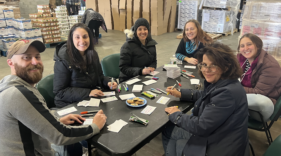 Volunteers write notes for Hanukkah, which are included in the survivors' food boxes. / Credit: CBS News/Met Council