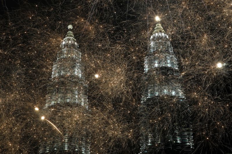 Fireworks explode near Petronas Twin Towers during New Year celebrations in Kuala Lumpur