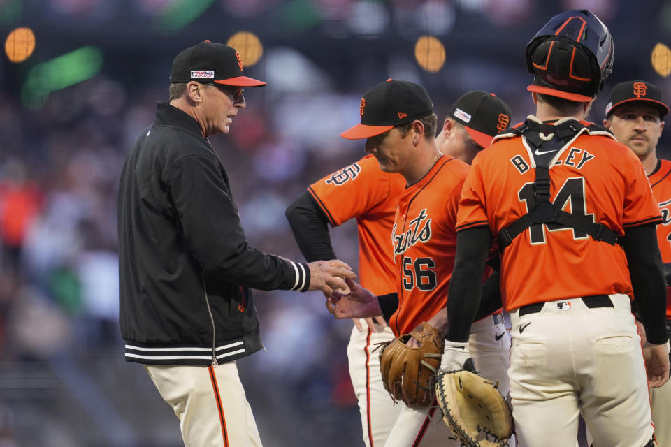 San Francisco Giants pitcher Spencer Howard (56) hands the ball to manager Bob Melvin, left, during the third inning of the team's baseball game against the Los Angeles Angels, Friday, June 14, 2024, in San Francisco. (AP Photo/Godofredo A. Vásquez)