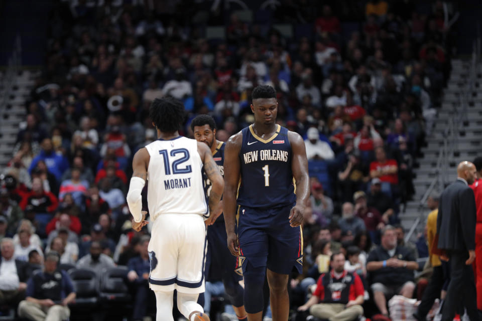 New Orleans Pelicans forward Zion Williamson (1) walks past Memphis Grizzlies guard Ja Morant (12) 