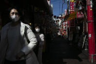In this Feb. 13, 2020, photo, two women wearing masks tour Yokohama's Chinatown, near Tokyo. A top Olympic official made clear Friday the 2020 Games in Tokyo will not be cancelled despite the virus that has spread from China. (AP Photo/Jae C. Hong)
