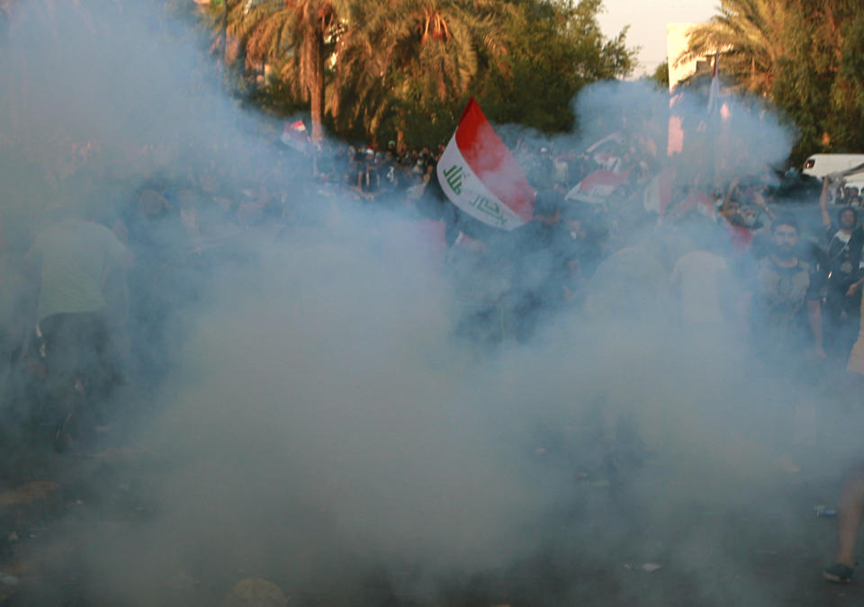 Iraqi security forces fire tear gas to disperse anti-government protesters during a demonstration in Tahrir Square, Baghdad, Iraq, Saturday, Oct. 26, 2019. Iraqi protesters converged on a central square in the capital Baghdad on Saturday as security forces erected blast walls to prevent them from reaching a heavily fortified government area after a day of violence that killed scores. (AP Photo/Khalid Mohammed)