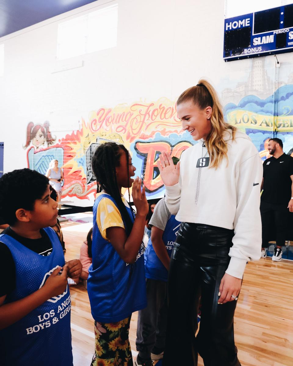 Sabrina Ionescu meets with children at the unveiling of the refurbished basketball gym at the Los Angeles Boys and Girls Club.