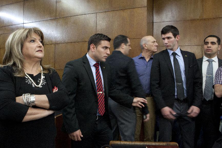 Former Israel Prime Minister Ehud Olmert, in the blue shirt, and his former aid Shula Zaken, left, attend a hearing in a corruption case, at Tel Aviv's District Court, Monday, March 31, 2014. The court handed down the verdict in the wide-ranging Jerusalem real estate scandal case related to Olmert’s activities before becoming prime minister in 2006. A total of 13 government officials, developers and other businesspeople were charged in three separate schemes. (AP Photo/Dan Balilty)