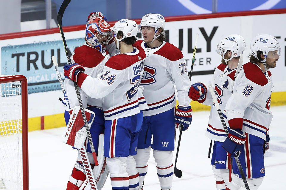 Montreal Canadiens' Phillip Danault (24) and Tyler Toffoli (73) celebrate with goaltender Carey Price (31) the team's win over the Winnipeg Jets in Game 2 of an NHL hockey Stanley Cup second-round playoff series Friday, June 4, 2021, in Winnipeg, Manitoba. (John Woods/The Canadian Press via AP)