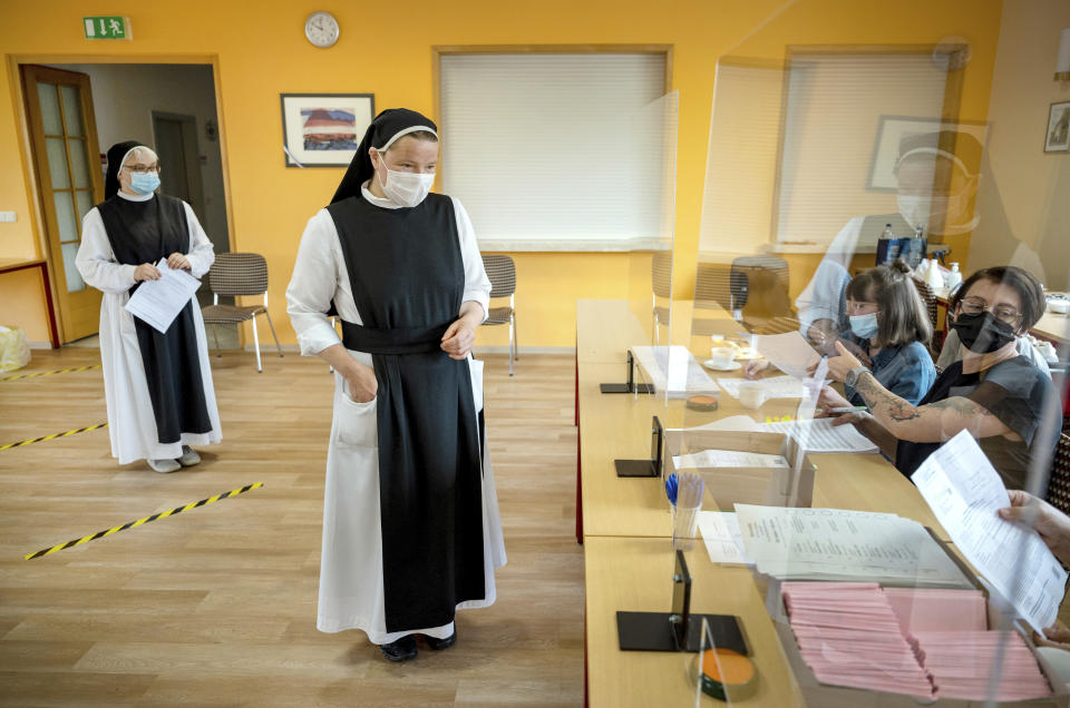 Sisters Pauline, left, and Gertrud from the Cistercian convent of Helfta arrive at the polling station during the state elections of German federal state Saxony-Anhalt, in the Helfta district of Eisleben, Germany, Sunday, June 6, 2021. The election for the new state parliament in Saxony-Anhalt is the last state election before the federal election in September 2021. (Hendrik Schmidt/dpa via AP)