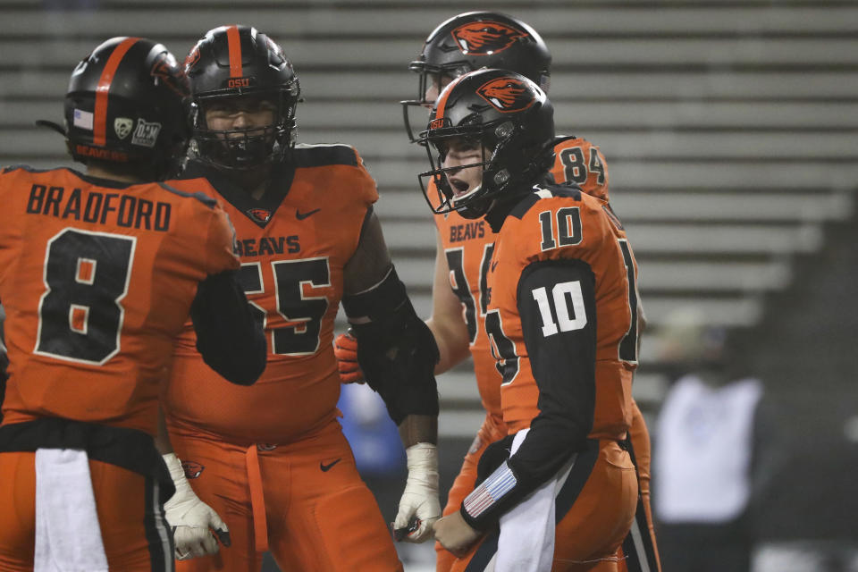 Oregon State quarterback Chance Nolan (10) celebrates his touchdown with Trevon Bradford (8), Keli'I Montibon (55) and Teagan Quitoriano (84) during the second half of the team's NCAA college football game against Oregon in Corvallis, Ore., Friday, Nov. 27, 2020. Oregon State won 41-38. (AP Photo/Amanda Loman)