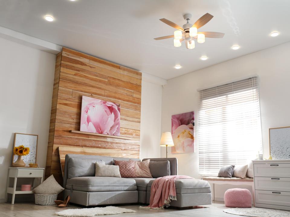 Stylish living room interior with modern ceiling fan and comfortable couch