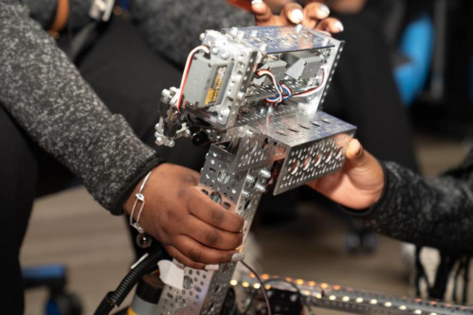 Members of the Skyline Robotics team at East St. Louis Senior High School lift the mechanism on their robot, Big Bernie, that picks up “pixels” on April 9, 2024.