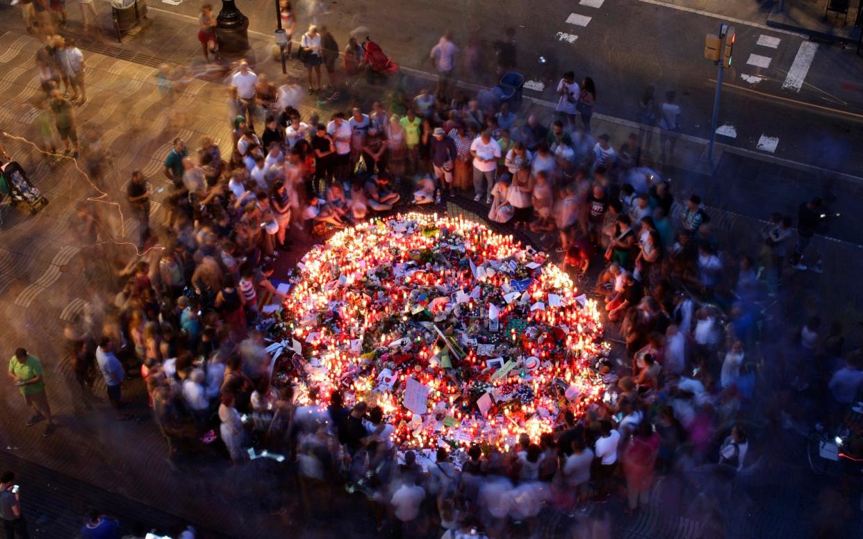 People gather at a memorial tribute of flowers, messages and candles to the victims on Barcelona's historic Las Ramblas promenade on the Joan Miro mosaic. - AP