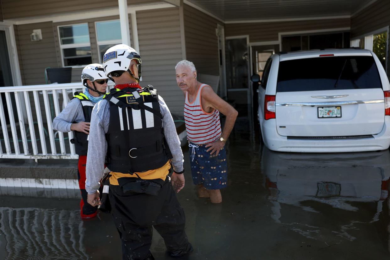 Frank Bruno speaks with members of the Texas A&M; Task Force 1 Search and Rescue team as they look for anyone needing help after Hurricane Ian passed through the area on September 30, 2022 in Fort Myers, Florida. Mr. Bruno said he road the storm out in his home and told the search team members that he was okay. 