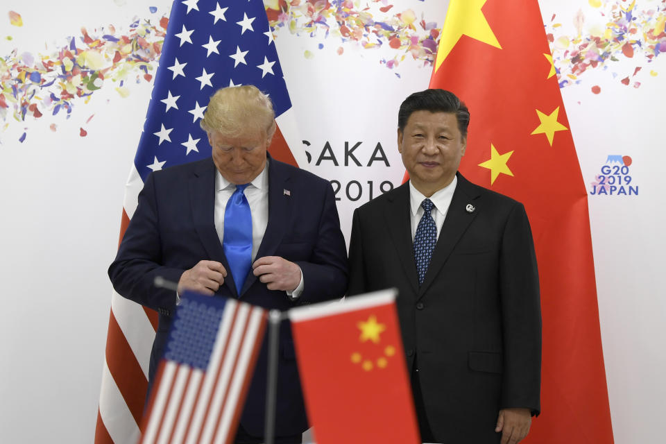 President Donald Trump adjusts his jacket as he poses for a photo with Chinese President Xi Jinping during a meeting on the sidelines of the G-20 summit in Osaka, Japan, Saturday, June 29, 2019. (AP Photo/Susan Walsh)