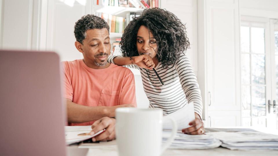 Couple and their financial planning in the kitchen with laptop.