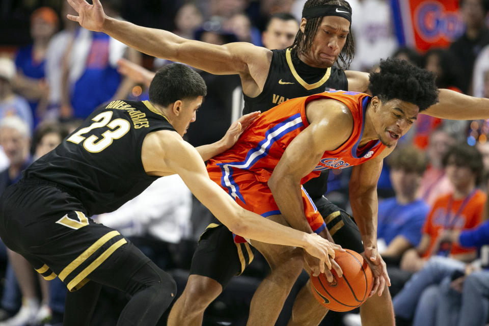 Vanderbilt guard Jason Rivera-Torres (23) knocks the ball loose from Florida guard Zyon Pullin,right, during the first half of an NCAA college basketball game, Saturday, Feb. 24, 2024, in Gainesville, Fla. (AP Photo/Alan Youngblood)