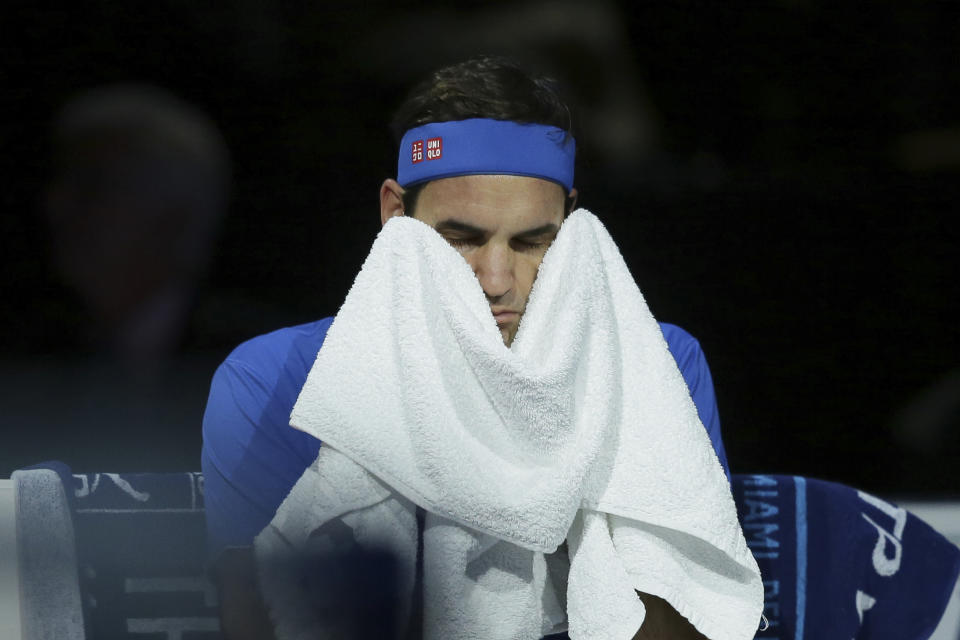 Roger Federer of Switzerland wipes his face with a towel during his ATP World Tour Finals singles tennis match against Alexander Zverev of Germany at the O2 Arena in London, Saturday Nov. 17, 2018. (AP Photo/Tim Ireland)