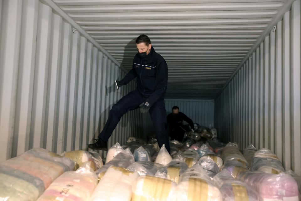 Belgian customs officers search for drugs in a container at the port of Antwerp