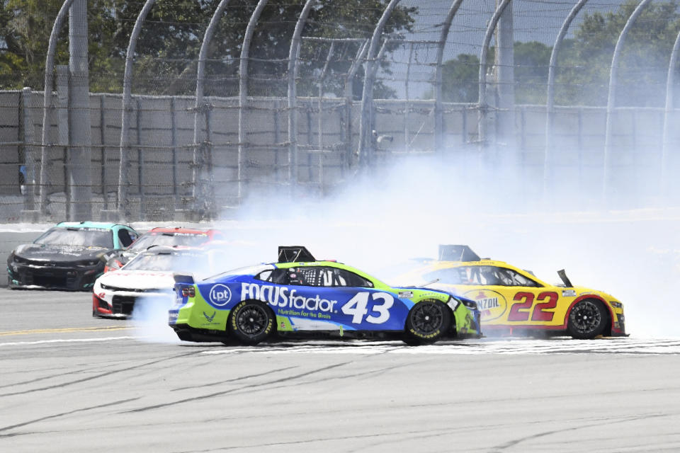 Erik Jones (43) and Joey Logano (22) lose control of their cars along the back stretch during a NASCAR Cup Series auto race at Daytona International Speedway, Sunday, Aug. 28, 2022, in Daytona Beach, Fla. (AP Photo/Don Howard)
