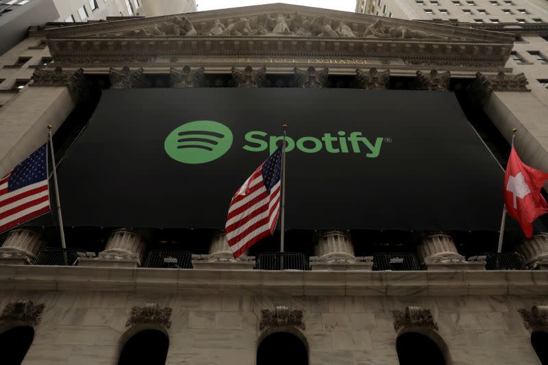 FILE PHOTO: The Spotify logo hangs on the facade of the New York Stock Exchange with U.S. and a Swiss flag as the company lists it's stock with a direct listing in New York