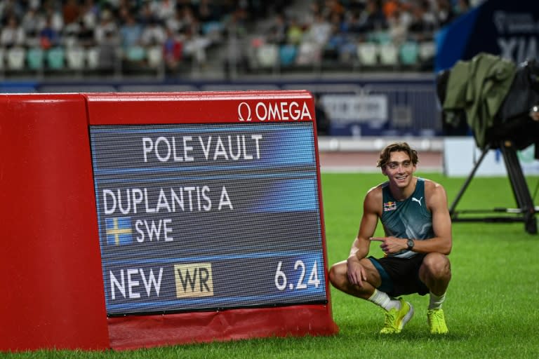 El sueco Armand Duplantis posa junto al marcador que señala el nuevo récord del mundo de salto con pértiga, en 6,24 metros, el 20 de abril de 2024 en la reunión de la Liga de Diamante de atletismo en Xiamen, China (Str)