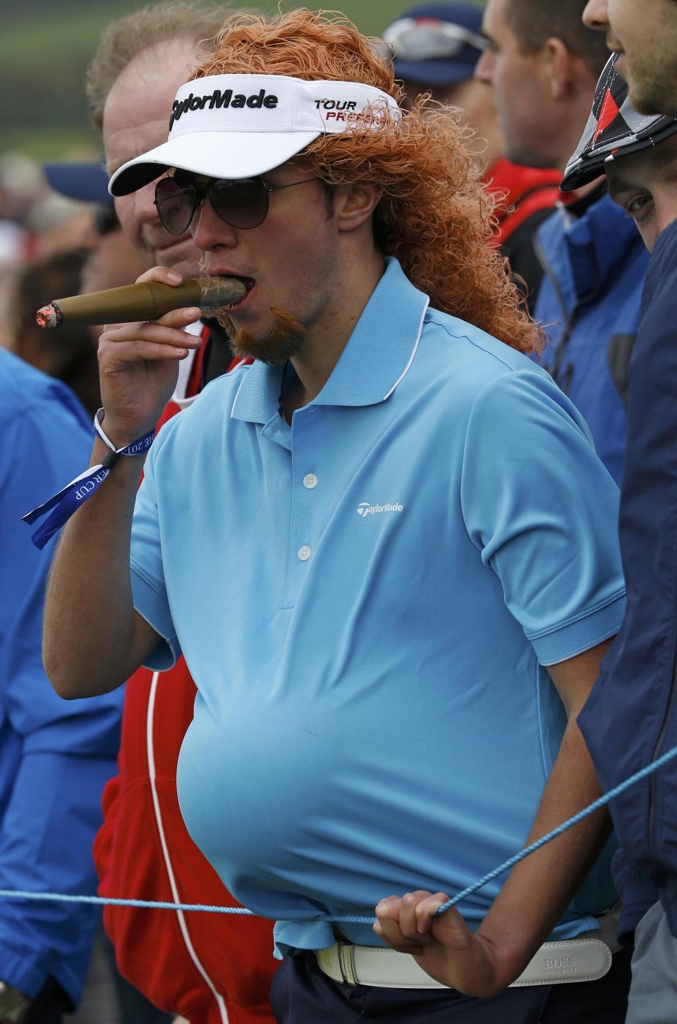 A spectator mimics European Ryder Cup vice-captain Miguel Angel Jimenez as he watches play on the eighth hole during the 40th Ryder Cup at Gleneagles in Scotland September 27, 2014. REUTERS/Russell Cheyne (BRITAIN - Tags: SPORT GOLF)