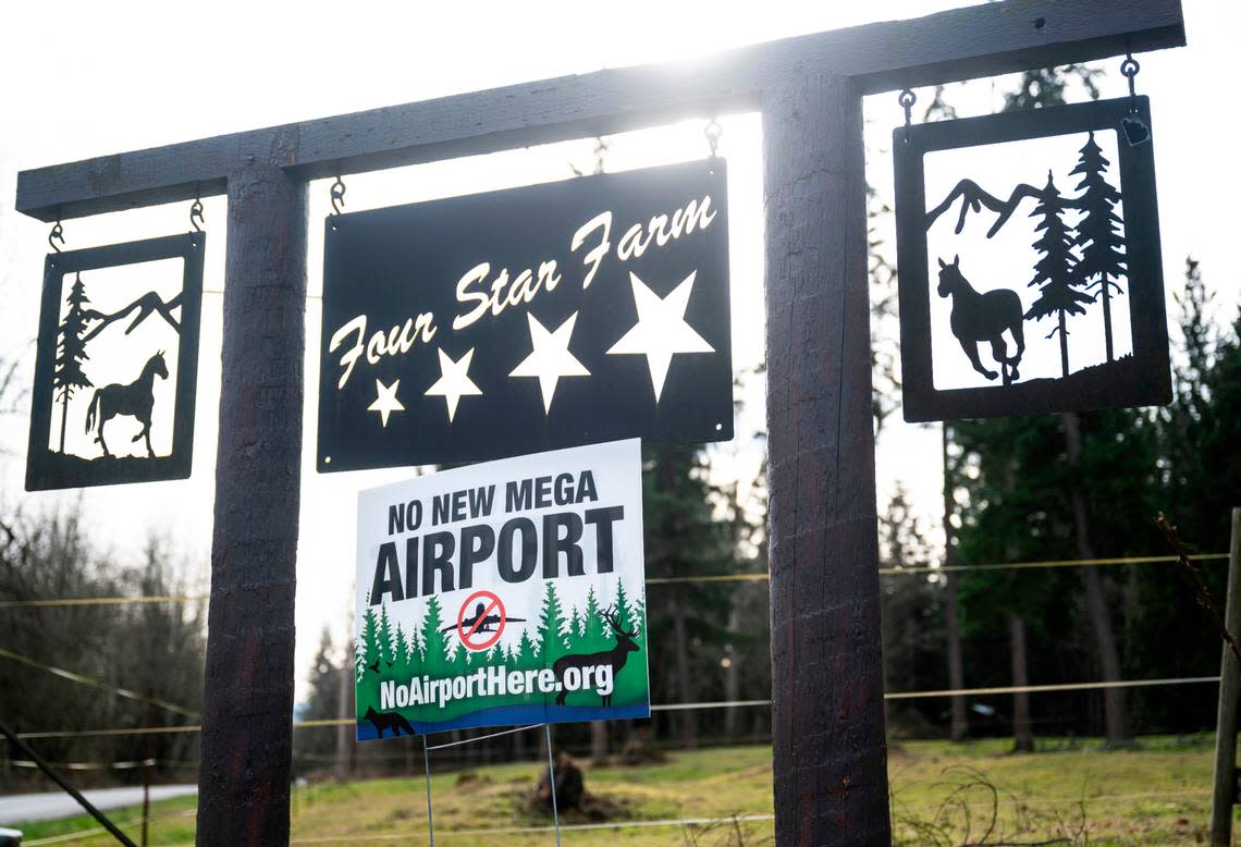 A sign opposing a new airport in Graham is positioned under Four Star Farm’s welcome sign in Graham on Jan. 31, 2023. Sharon Lulham and her daughter, Sholeh Lulham-New, are co-owners of Four Star Farms, where the nonprofit, Horses Guiding Humans, operates and helps over 50 clients receive equine-assisted mental health therapy each week.