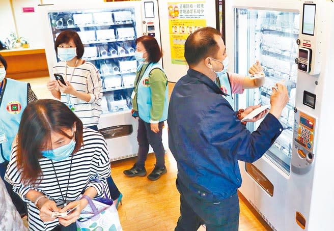 台北市口罩販賣機擬擴及12區，圖為設在台北市信義區行政中心的口罩販賣機，不少民眾到場選購口罩。（季志翔攝）