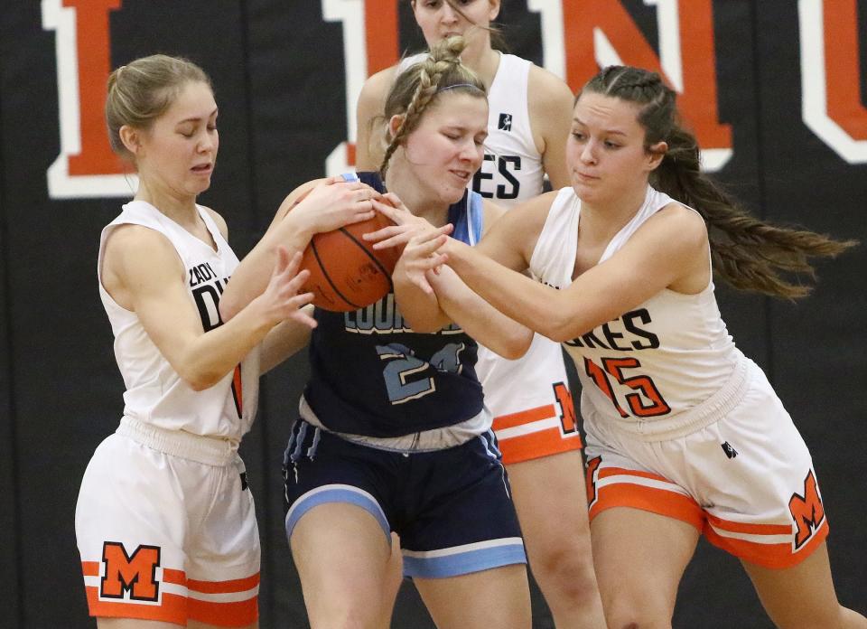 Marlington's Maria Warner and Ava Collins contest Louisville's Brooke Haren, center, for the ball during action Saturday afternoon at Marlington High School, January 28, 2023.