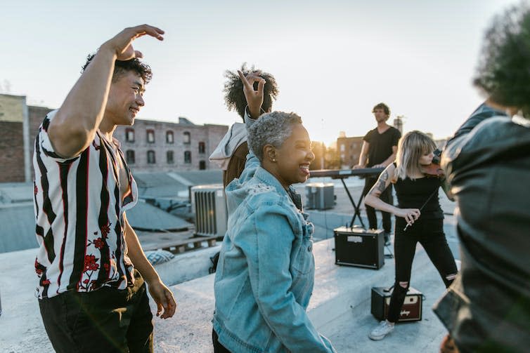 People dancing on rooftop.