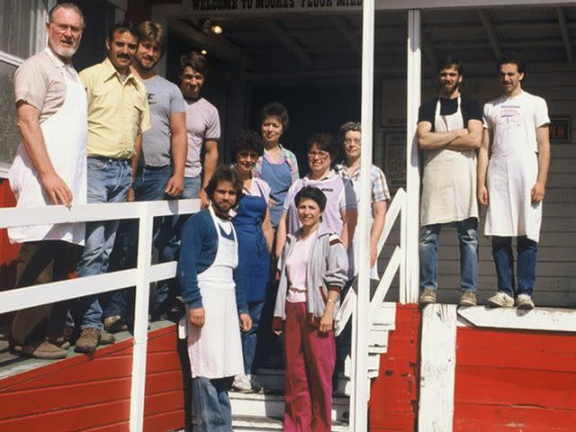 <p>Bob's Red Mill/Instagram</p> Moore pictured with his employees at his shop Moore's Flour Mill