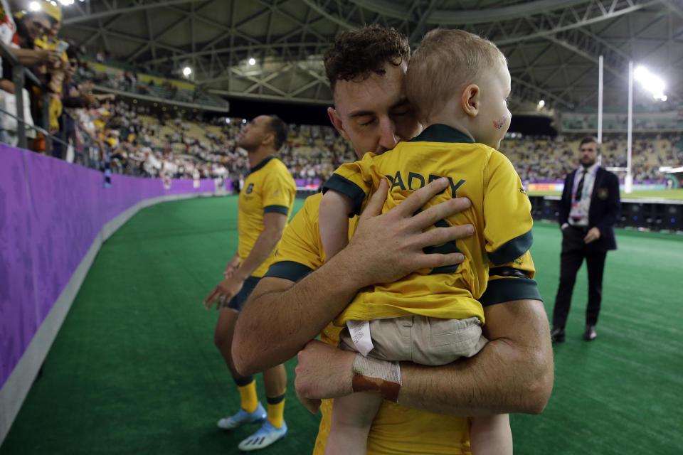 Australia's Nic White kisses his son after the Rugby World Cup quarterfinal match at Oita Stadium between England and Australia in Oita, Japan, Saturday, Oct. 19, 2019. England won 40-16. (AP Photo/Aaron Favila)