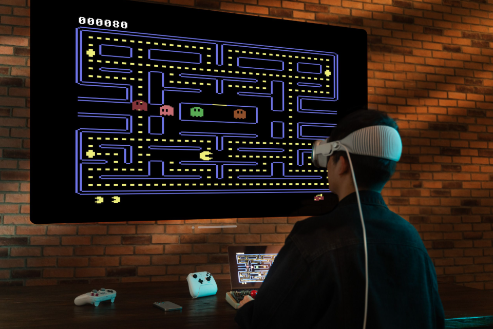 A person wearing headphones and playing Pac-Man.