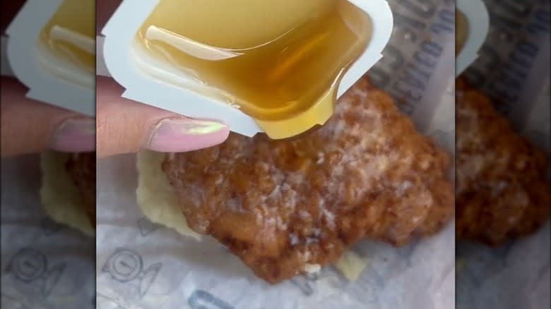 pouring honey on buttered chicken