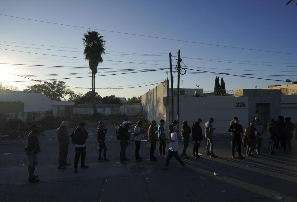 Venezuelan migrants line up to receive a ticket for a date application for asylum in the U.S., in Matamoros, Mexico, Thursday, Dec. 22, 2022. (AP Photo/Fernando Llano)