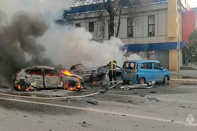 En esta imagen de archivo, tomada de un video distribuido por el Ministerio de Emergencias de Rusia en su canal de Telegram el 30 de diciembre de 2023, bomberos sofocan autos en llamas tras un ataque sobre Belgorod, Rusia. (Ministerio de Emergencias de Rusia vía AP, archivo)