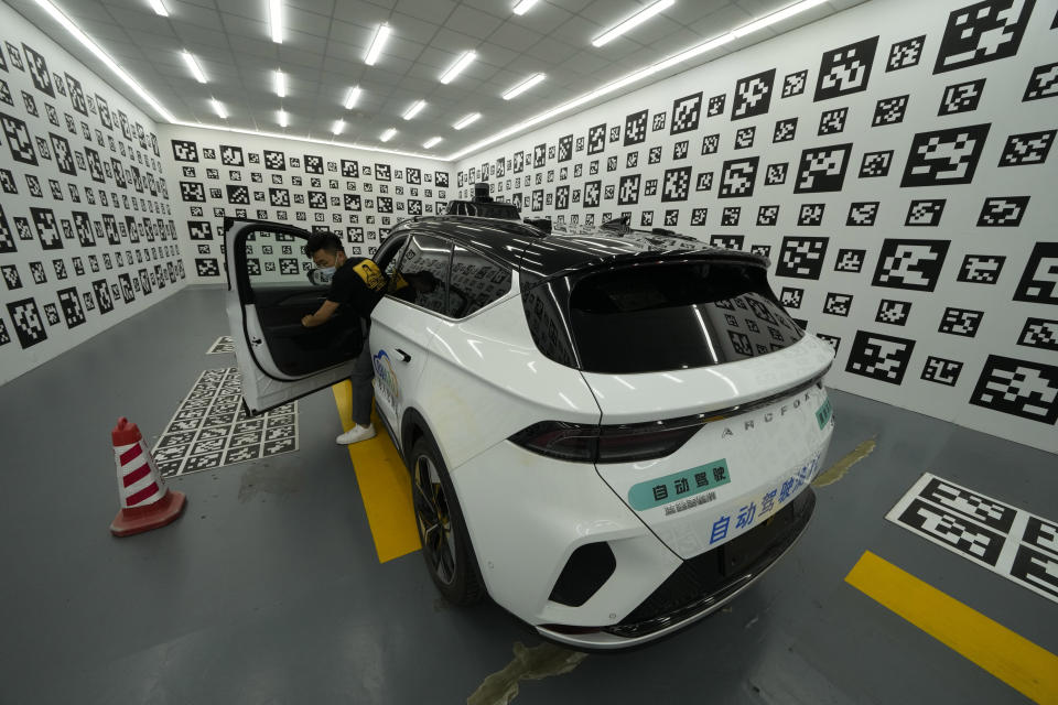 A driver leaves a car after parking it in a chamber used to calibrate the self-driving taxi developed by tech giant Baidu Inc. on June 14, 2022, in Beijing. Baidu Inc. is China's highest-profile competitor in a multibillion-dollar race with Alphabet Inc.'s Waymo and General Motors Co.'s Cruise to create self-driving cars. (AP Photo/Ng Han Guan)